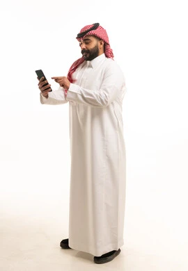 Saudi Man in Traditional Thobe Using Smartphone