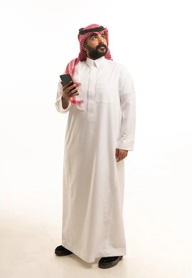 Saudi Man in Traditional Thobe Holding Smartphone Studio