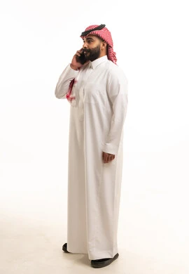 Saudi Man in Traditional Thobe Using Smartphone