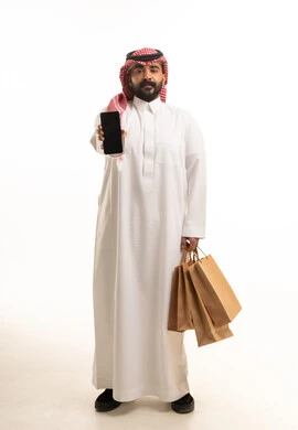 Saudi Man Holding Smartphone and Shopping Bags in Studio