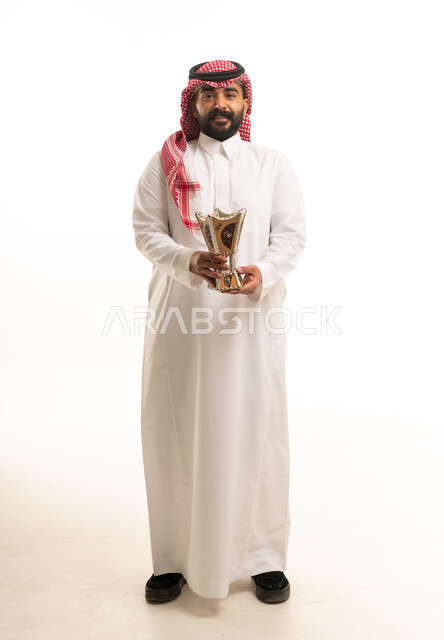 رجل سعودي بالثوب التقليدي يحمل مبخرة بخور في استوديو