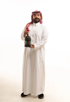 رجل سعودي يحمل فانوس رمضان بخلفية بيضاء