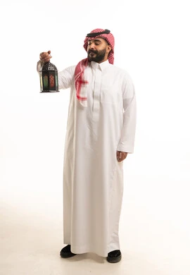 رجل سعودي بالثوب التقليدي يمسك فانوس رمضان