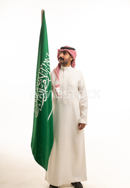 رجل سعودي يمسك العلم الوطني على خلفية بيضاء