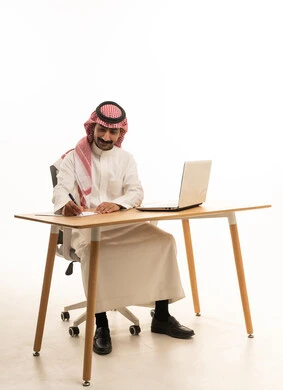 Saudi Businessman Working at Office Desk with Laptop