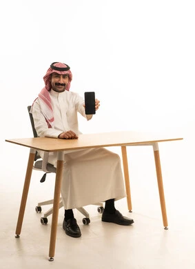 رجل سعودي يحمل هاتف ذكي في استوديو