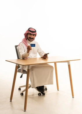 Saudi Man with Credit Card and Smartphone at Desk