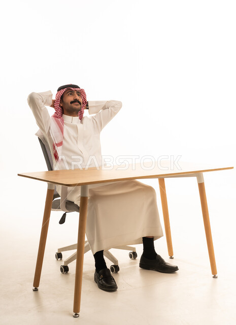 رجل سعودي يسترخي على مكتب العمل