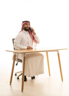 Saudi Man Using Smartphone at Office Desk
