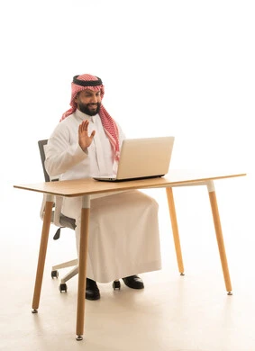 Saudi Man in Traditional Dress Using Laptop for Video Call
