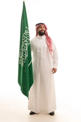 Saudi Man Holding Saudi Arabia Flag in Traditional Dress