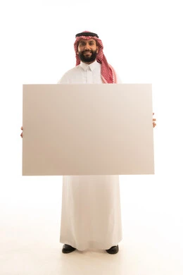 رجل سعودي يحمل لوحة بيضاء فارغة في الاستوديو