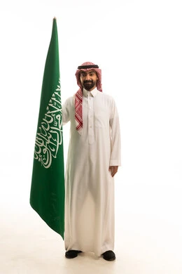 Saudi Man in Traditional Dress Holding National Flag