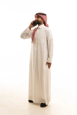Saudi Man in Traditional Dress Talking on Smartphone