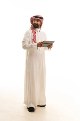 رجل سعودي بالزي التقليدي يحمل جهاز لوحي