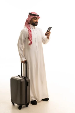رجل سعودي مسافر مع حقيبة سفر وهاتف ذكي
