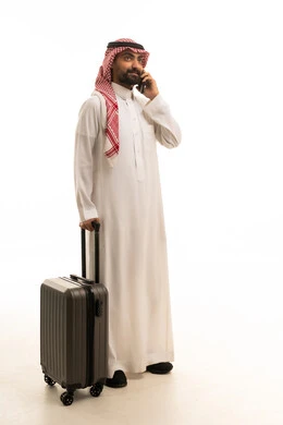 Saudi Man in Thobe with Suitcase Talking on Phone
