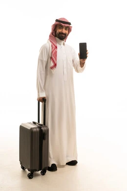 رجل سعودي يحمل حقيبة سفر وهاتف ذكي خلفية بيضاء