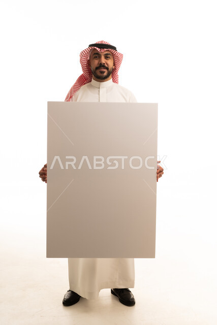 Saudi Man in Traditional Dress Holding Blank White Board