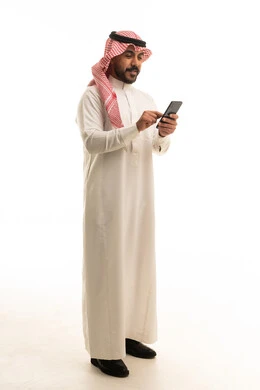 رجل سعودي بالزي التقليدي يستخدم الهاتف الذكي