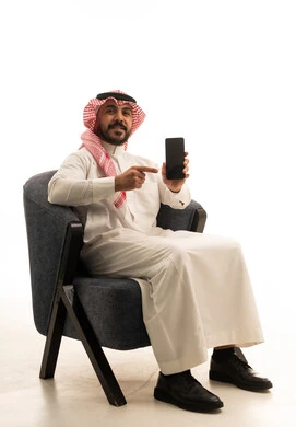 Saudi Man in Traditional Thobe Pointing at Smartphone