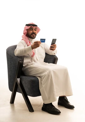 رجل سعودي يستخدم بطاقة الائتمان والهاتف الذكي