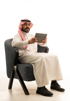 Saudi Man in Traditional Thobe Holding Tablet Computer