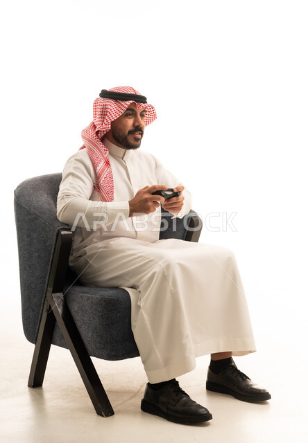 Saudi Man Gaming in Traditional Thobe Studio