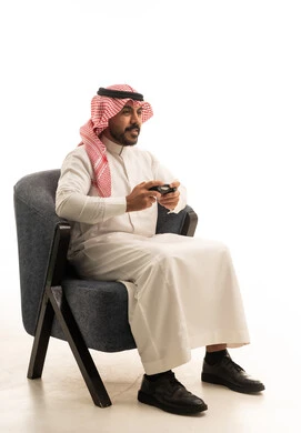 Saudi Man Gaming in Traditional Thobe Studio