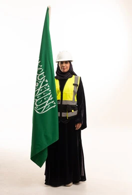 مهندسة سعودية تحمل العلم بزي السلامة المهني
