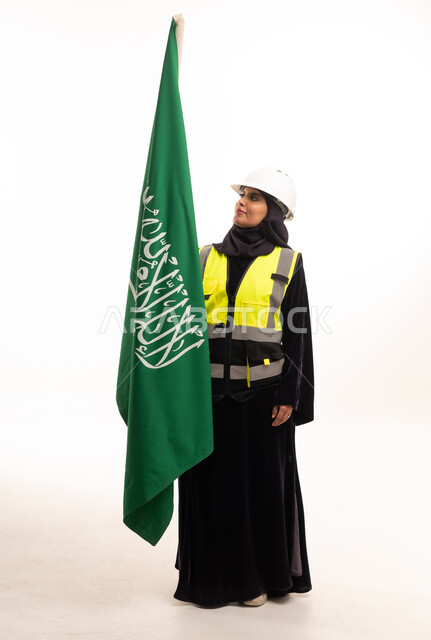 مهندسة سعودية مع العلم الوطني في استوديو