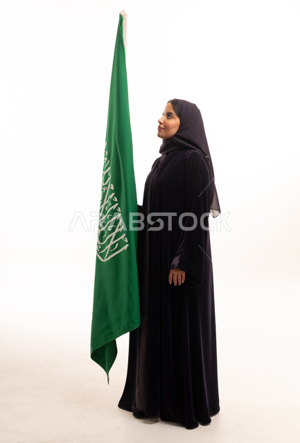 امرأة سعودية مع العلم الوطني في الاستوديو