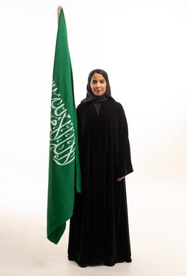 Saudi Woman in Black Abaya Standing With Saudi Flag