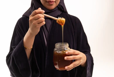 Saudi Woman Holding Honey Jar with Wooden Dipper