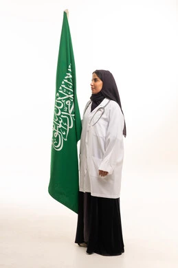 طبيبة سعودية تقف مع العلم الوطني السعودي