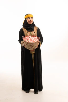 امرأة سعودية بالزي التقليدي الطائفي مع سلة ورد