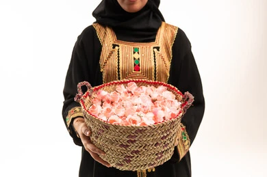 امرأة سعودية تحمل ورد الطائف بالزي التقليدي