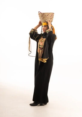 امرأة سعودية بالزي التقليدي تحمل سلة خوص