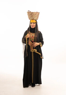 امرأة سعودية بالزي التقليدي التراثي وسلة الخوص