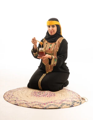 Emirati Woman in Traditional Mukhawar Holding a Honey Jar