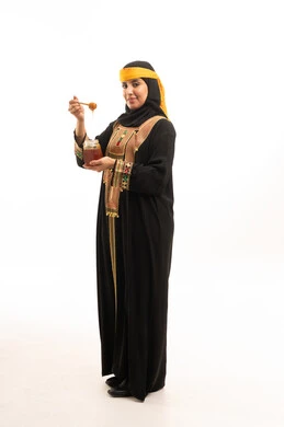 Saudi Woman in Traditional Dress Holding Honey Jar