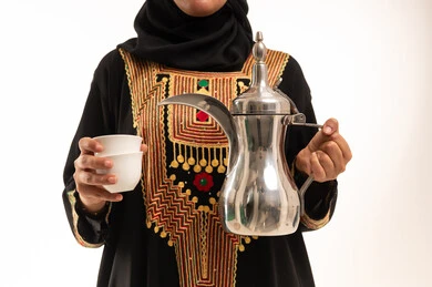 Saudi Woman in Traditional Dress Holding Arabic Coffee Dallah