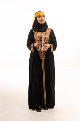 امرأة سعودية بالعباءة التقليدية تحمل مبخرة خشبية