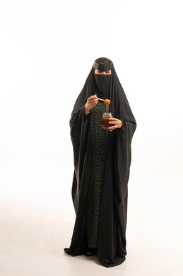 Saudi Woman in Niqab Holding Honey Jar in Studio