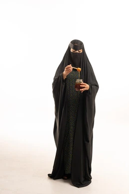 Saudi Woman in Niqab Holding Honey Jar in Studio