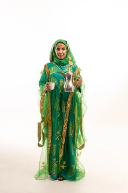 Saudi Woman in Traditional Green Dress with Dallah