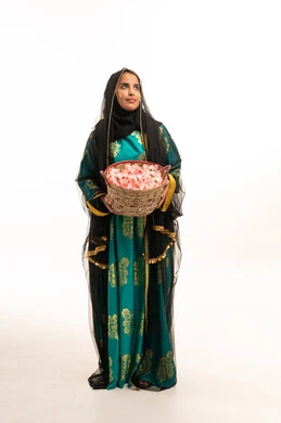 Omani Woman in Traditional Green Dress with Rose Basket