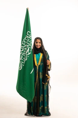 امرأة سعودية مع العلم الوطني بالزي التقليدي امرأة سعودية مع العلم الوطني بالزي التقليدي