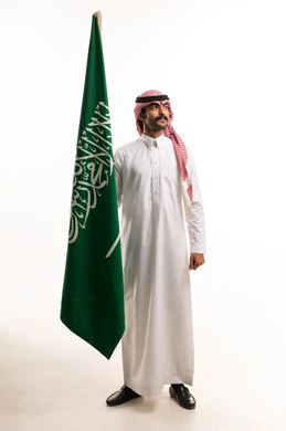 Saudi Man in Traditional Dress Holding National Flag
