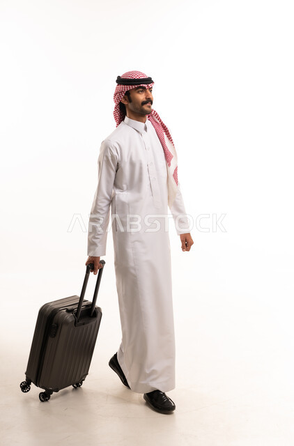 رجل سعودي بالزي التقليدي مع حقيبة سفر
